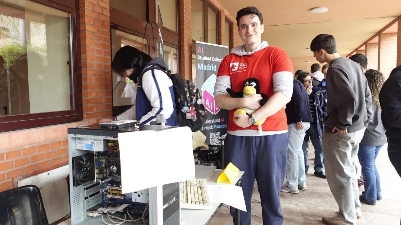 GUL en la Feria de Asociaciones. El presi con camiseta roja del GUL abrazando a un peluche de Tux