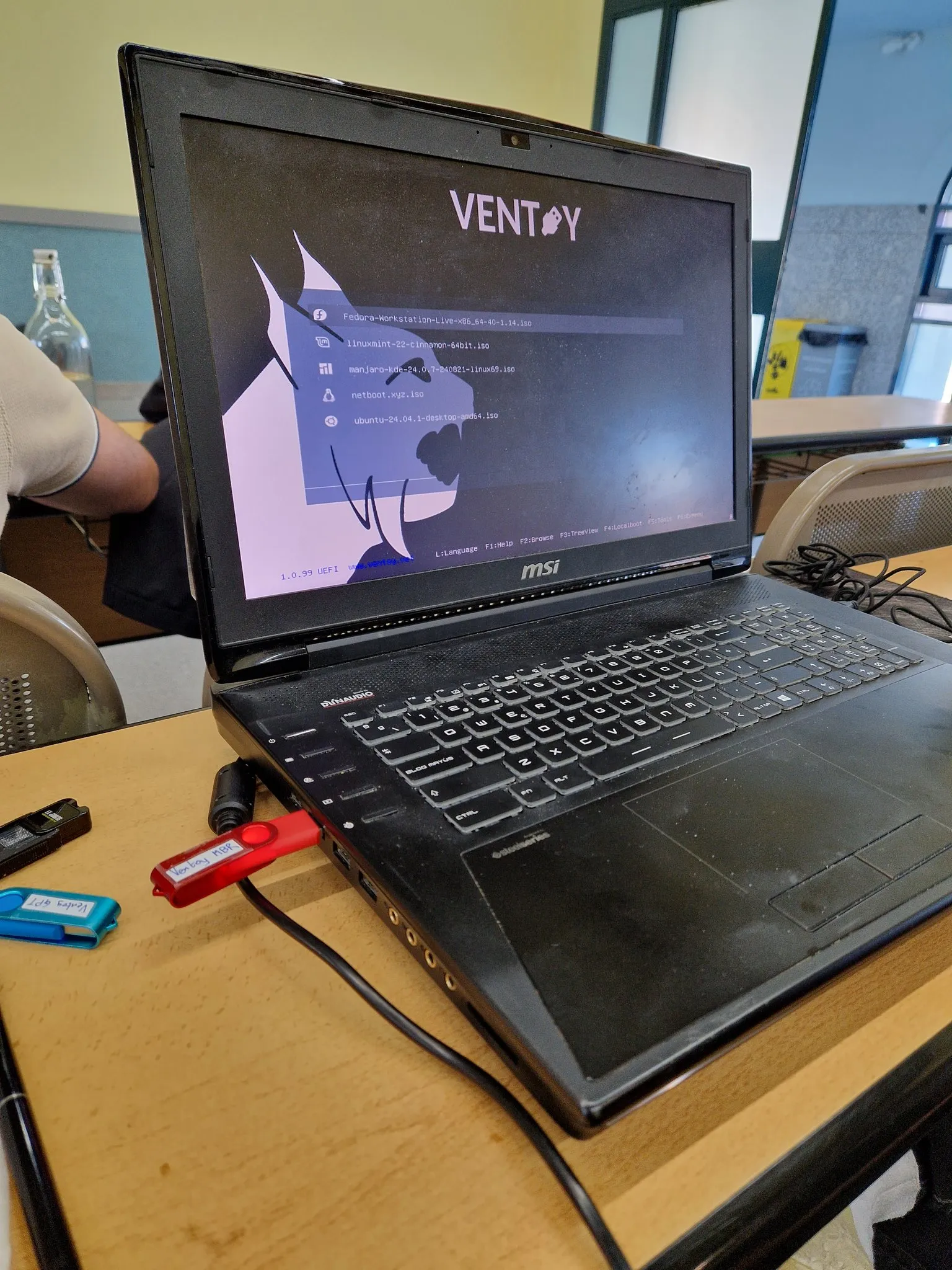Portátil instalando Linux con Ventoy y un fondo del GUL